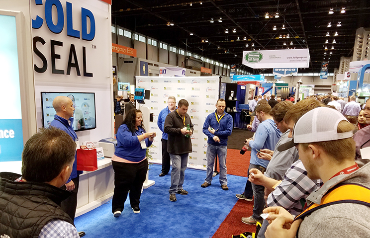 Visitors wait in the Ideal Tape booth for the daily YETI raffle winner to be called.