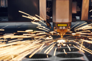 A close-up shot of a laser cutting designs out of sheet metal